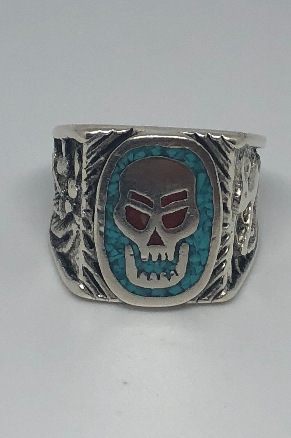 Skull ring with blue turquoise and red coral in white bronze on white background